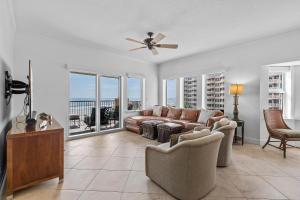 a living room with a couch and a ceiling fan at Atlantic Villas 301 in New Smyrna Beach