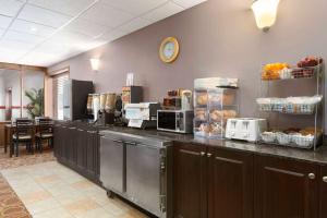 Una cocina con encimera con alimentos y electrodomésticos. en Travelodge by Wyndham Meadow Lake, en Meadow Lake