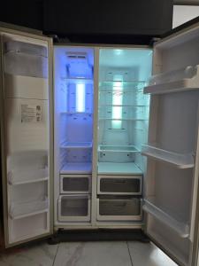 un frigorifero vuoto con le sue porte aperte in una cucina di Sunshell luxury apartment a Lija
