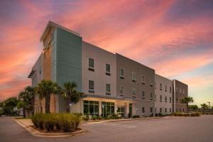 a large building with a sunset in the sky at Comfort Inn Miramar Beach-Destin in Destin