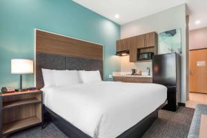 a bedroom with a large white bed and a kitchen at Comfort Inn Miramar Beach-Destin in Destin +37 photos