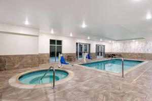 a pool in a hotel room with blue chairs and a swimming pool at La Quinta Inn & Suites by Wyndham Wenatchee in Wenatchee