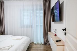 a bedroom with a bed and a television on a wall at Zian Apartament in Craiova