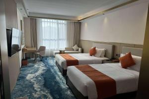 a hotel room with two beds and a desk at Wyndham Garden Rizhao Donggang Resort in Rizhao