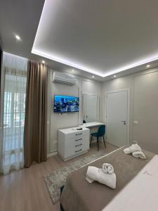 a bedroom with a bed and a desk and a tv at Glenis Apartment Vollga in Durrës