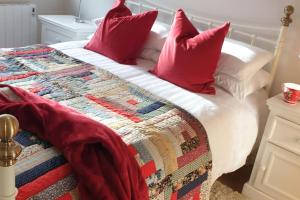un letto con cuscini rossi e una trapunta sopra di Tom Jacks, coastal views and beach walks Connemara a Galway