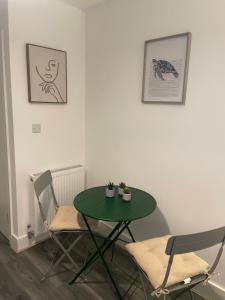 una mesa verde y sillas en una habitación en Amazing studios 2 - East London, en Londres 10 fotos más