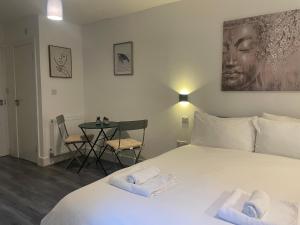 Un dormitorio con una cama y una mesa con sillas. en Amazing studios 2 - East London, en Londres