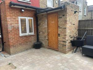 una casa de ladrillo con una puerta de madera y una ventana en Amazing studios 2 - East London, en Londres