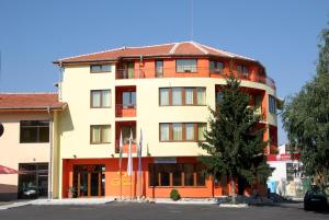 an apartment building with a tree in front of it at Hotel Grand in Samokov