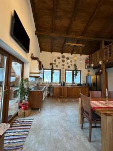 a large kitchen and dining room with a dining table at La Casetta - O întreagă căsuță ca în povești in Baia-Sprie