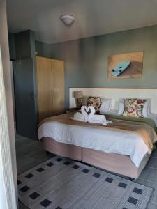 a bedroom with a large bed with a surfboard on it at Pili Pili Beach Cabanas in Sedgefield