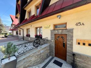 budynek z brązowymi drzwiami i balkonem w obiekcie Apartamenty Bukowina w Bukowinie Tatrzańskiej