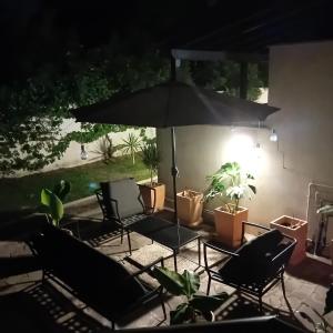 a patio with chairs and an umbrella and plants at Casa Bibi in Infernetto