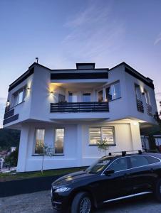 a black car parked in front of a white house at Villa Lea Tuzla in Tuzla