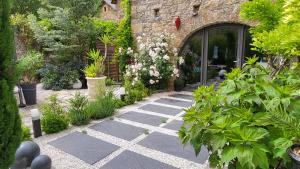 a garden with plants and a stone walkway at Le Mas ROLLAND -Chambres de charme -SPA sauna & jacuzzi - Label Qualité Tourisme Occitanie - Millau - Gorges du Tarn in Compeyre +47 photos