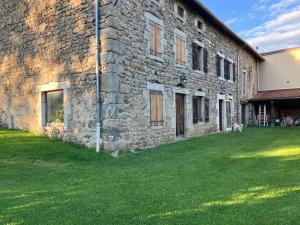 a stone building with a grass yard in front of it at Relais nofeer in Monlet