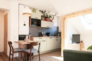 a kitchen with a table and chairs in a room at En plein centre du village ! in Villard-de-Lans