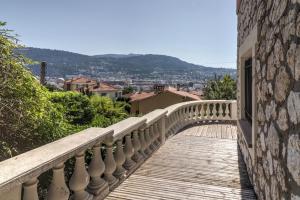 a balcony with a stone wall and a bridge at Villa spacieuse, totalement adaptée aux normes PMR in Nice