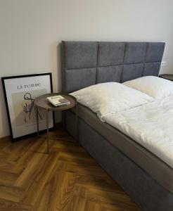 a bed in a room with a side table at SILVER apartment - Rezidencia Bojnice in Bojnice