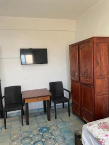 a room with a table and two chairs and a tv at Jara Cimrmann surf house in Imsouane +2 photos