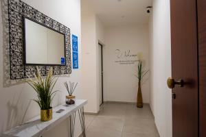 a hallway with a mirror and a table with plants at SMART Rooms Pistoia in Pistoia