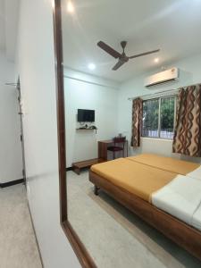 a bedroom with a bed and a tv and a mirror at Hotel Parth Residency in Kolhapur