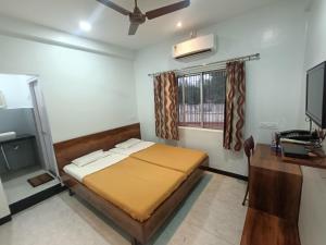 a bedroom with a bed and a desk and a television at Hotel Parth Residency in Kolhapur +33 photos