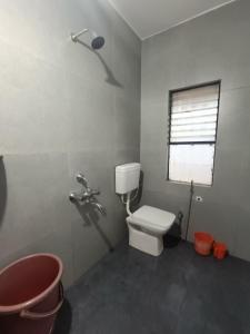 a bathroom with a white toilet and a window at Hotel Parth Residency in Kolhapur
