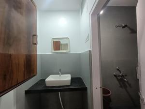 a small bathroom with a sink and a shower at Hotel Parth Residency in Kolhapur