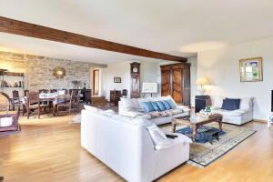 a living room with white furniture and a stone wall at Saint-Fortunat - Authentic Home with Pool - Saint-Didier-au-Mont-d'Or in Saint-Didier-au-Mont-dʼOr
