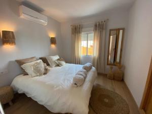 a bedroom with a large white bed with a mirror at Casa Boho in Cumbre del Sol +11 photos