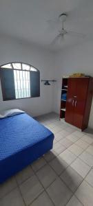 a bedroom with a blue bed and a cabinet at Sua casa longe de casa in Mongaguá