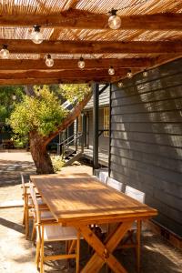 a wooden table and chairs under a wooden pergola at Seahorse Manor, The South Coast Sandcastles in Huskisson