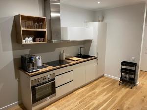 a kitchen with white cabinets and a stove top oven at Suite am Meer / Seaside suite in Ķesterciems