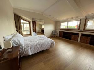 ein Schlafzimmer mit einem Bett, einem Schreibtisch und Fenstern in der Unterkunft CasaPlayaPatos,com Panxón in Nigrán