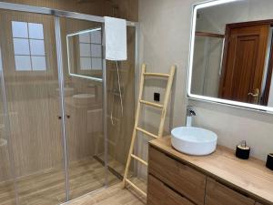 ein Badezimmer mit Dusche, Waschbecken und Spiegel in der Unterkunft CasaPlayaPatos,com Panxón in Nigrán + 8 Fotos