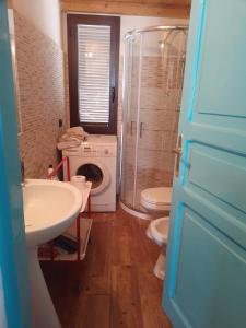 ein Badezimmer mit einer Waschmaschine, einer Waschmaschine und einem Trockner in der Unterkunft Casa in campagna in Capoterra