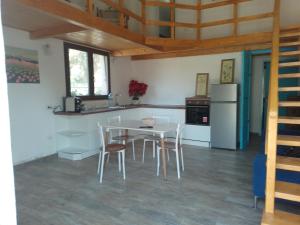 eine Küche mit Tisch und Stühlen und einem Kühlschrank in der Unterkunft Casa in campagna in Capoterra + 5 Fotos