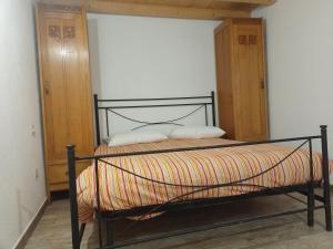 ein schwarzes Bett mit zwei Kissen darauf in einem Zimmer in der Unterkunft Casa in campagna in Capoterra