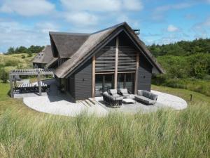 a log cabin with a thatched roof and chairs at Sig Ward (12p) in Nes