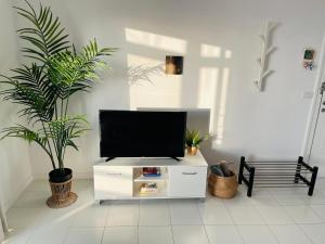 a living room with a flat screen tv on a white cabinet at The Green Terrace in Bajamar