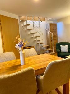 Ferienwohnung Kinnerstuw في بريرو: طاولة غرفة الطعام مع إناء من الزهور عليها