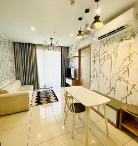 a living room with a table and a couch at Căn hộ VINHOMES GRAND PARK, Hồ Chí Minh city in Long Bình