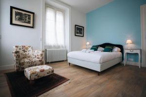 ein Schlafzimmer mit einem Bett und einem Stuhl in der Unterkunft L'Écrin - Stationnement Privatif - Coeur de ville in Châteauroux