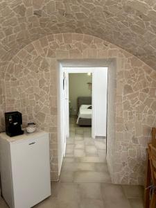 a room with a stone wall and a white refrigerator at Ercolano Civitas in Ercolano