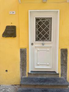 a white door on the side of a yellow building at Ercolano Civitas in Ercolano