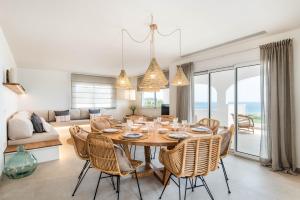 Un comedor y una sala de estar con mesa y sillas. en Villa Atalis 50 by Menorcarentals, en Son Bou