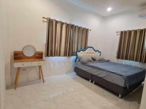 a bedroom with a bed and a desk and a mirror at Huahin Friends Pool Villa 1 in Hua Hin +8 photos