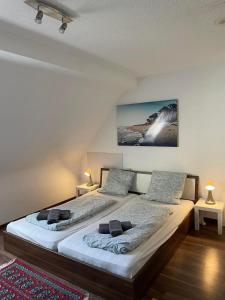 two twin beds in a room with two lamps at ESER Hotel Apartment in Hertingen